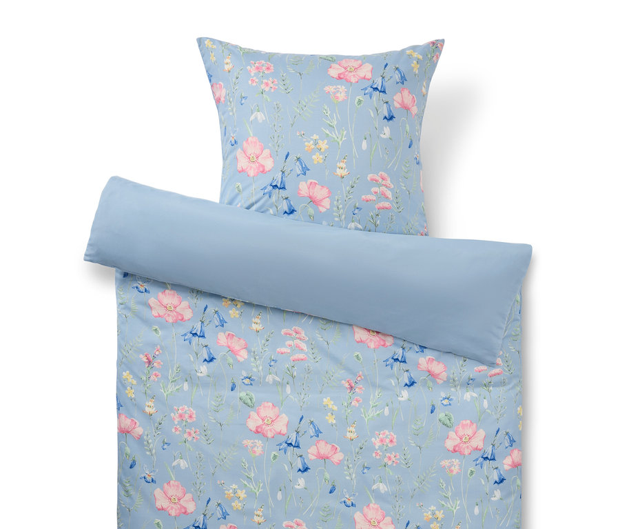 Linge de lit bleu clair à motif floral composé d'une taie d'oreiller, d'une housse de couette et d'un traversin.