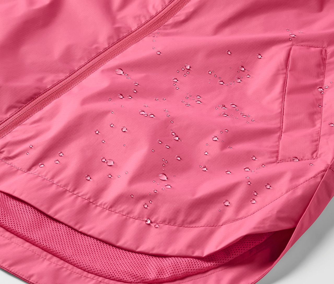Détail d'une veste de pluie rose avec des gouttes d'eau.