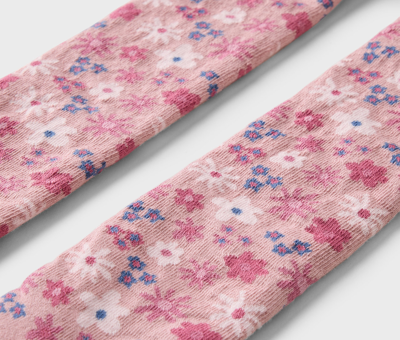 Gros plan sur trois paires de collants pour enfants avec un motif floral.