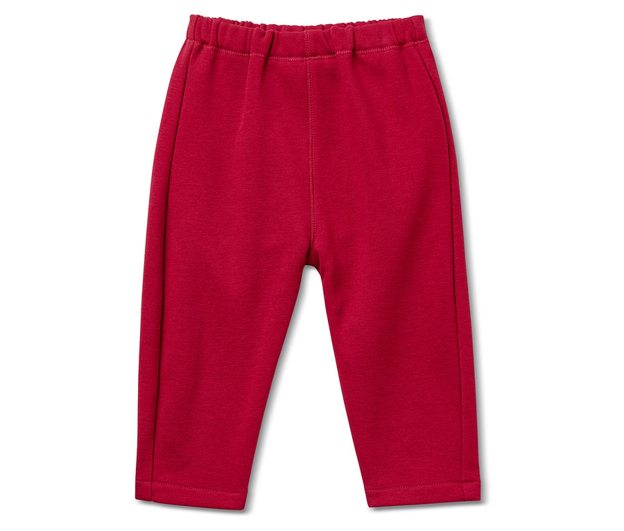 Un pantalon de survêtement rouge avec une taille élastique repose sur un fond blanc.