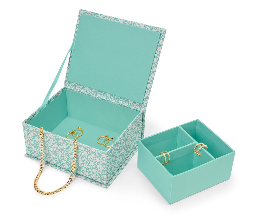 Boîte à bijoux turquoise à motif floral ouverte avec collier en or et bagues à l'intérieur, à côté d'un organisateur de bijoux turquoise.