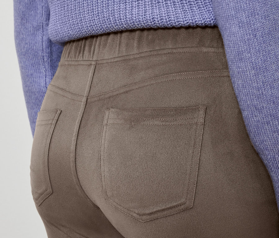 Gros plan d'un pantalon marron et d'un pull violet.