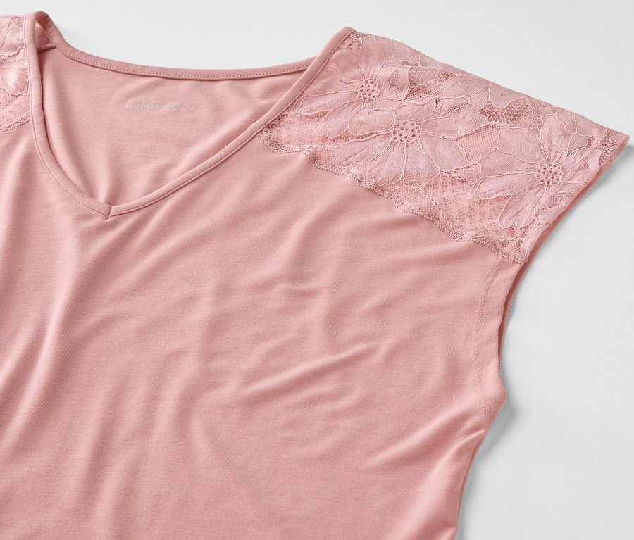 Gros plan d'un haut rose avec des manches en dentelle.