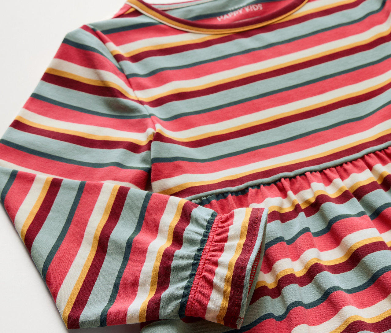 Gros plan d'une robe jersey pour enfants avec des rayures colorées.