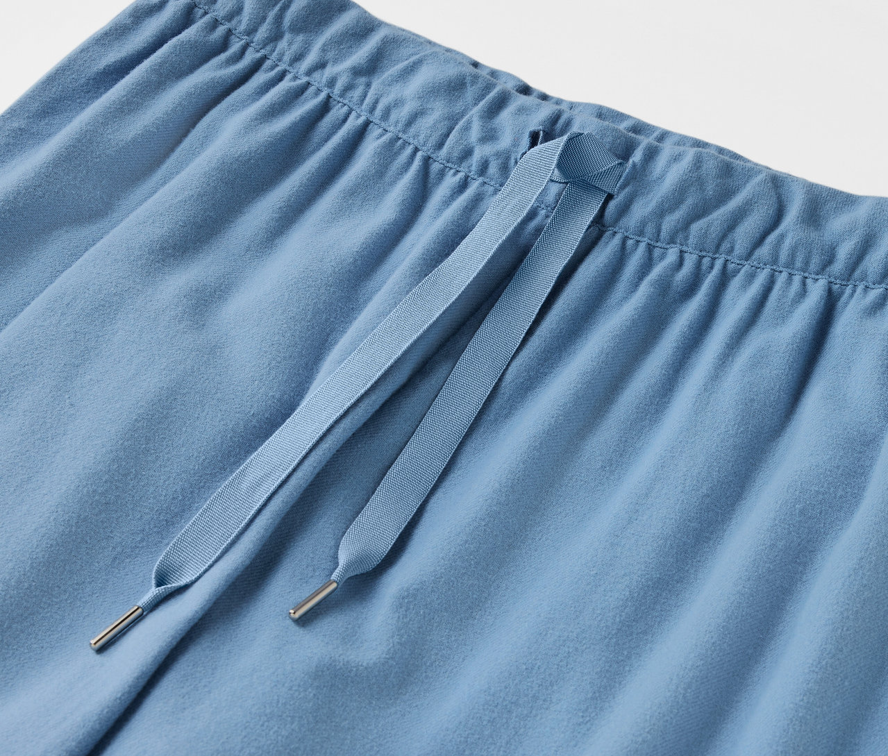 Gros plan d'un pantalon bleu clair avec cordon de serrage.