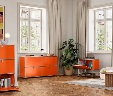 Salon avec armoires métalliques orange »CN3« avec compartiments à rabat.