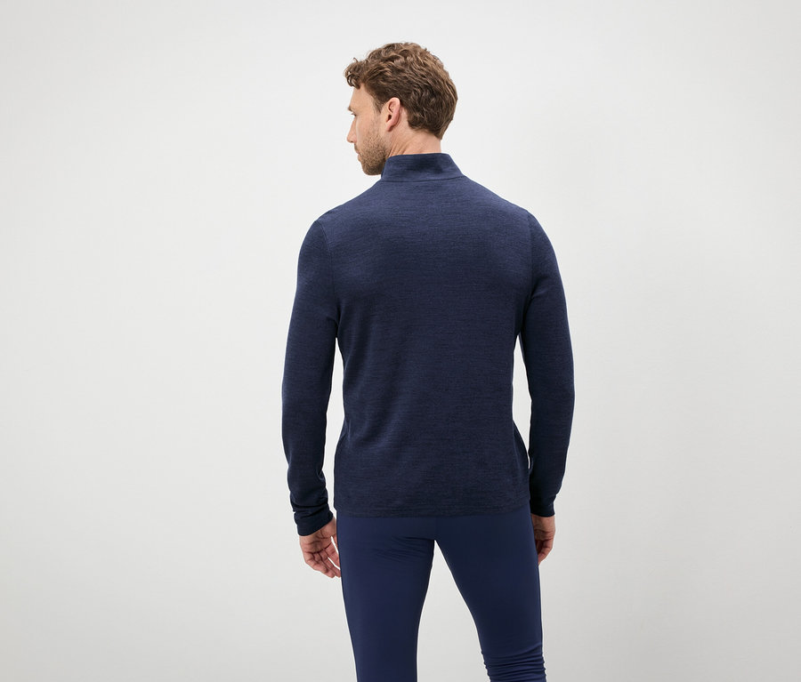 Un homme vu de dos porte un pull et un pantalon bleus.
