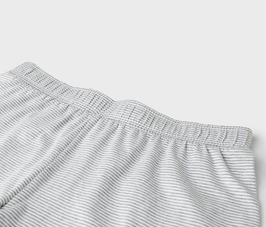 Détail d'un pantalon rayé gris avec une taille élastique.