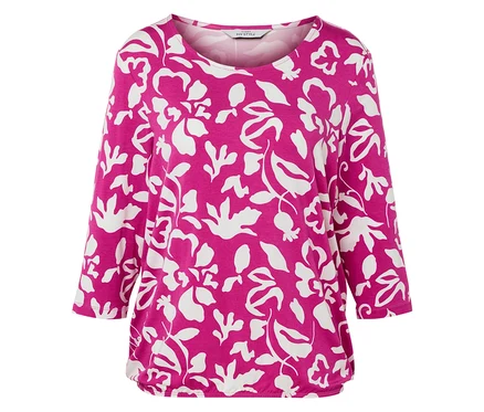 Un haut rose avec un motif floral blanc sur fond blanc.