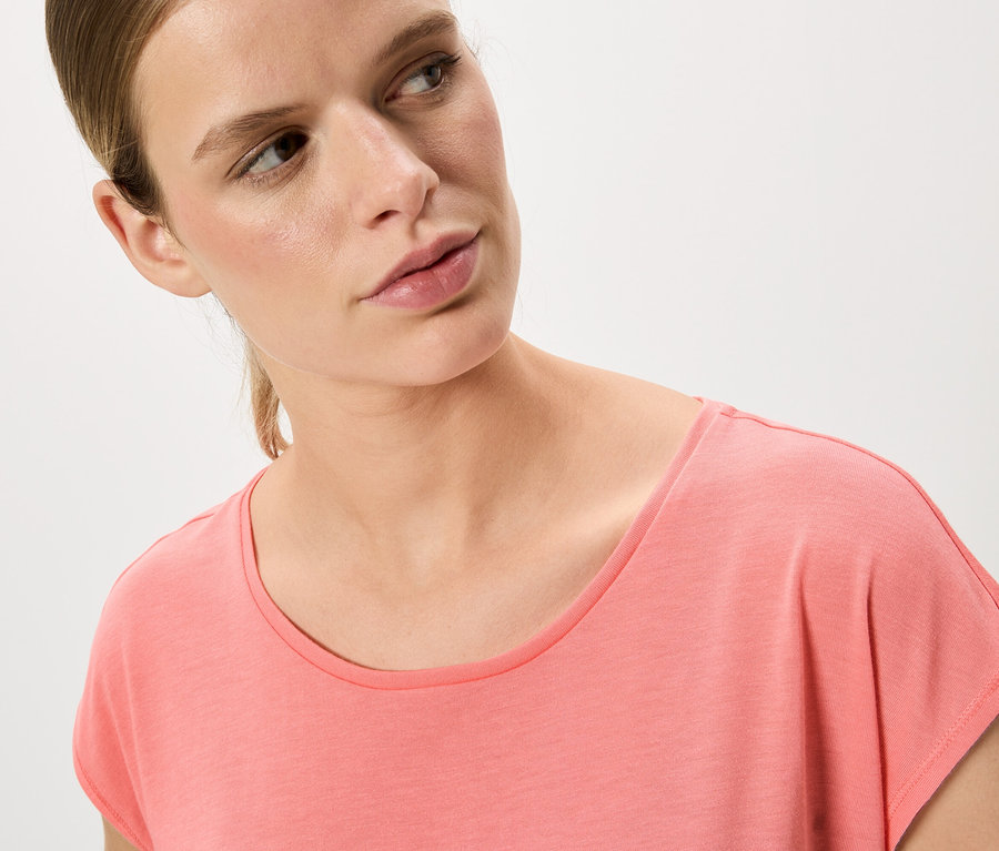 Portrait d'une femme blonde portant un t-shirt rose.