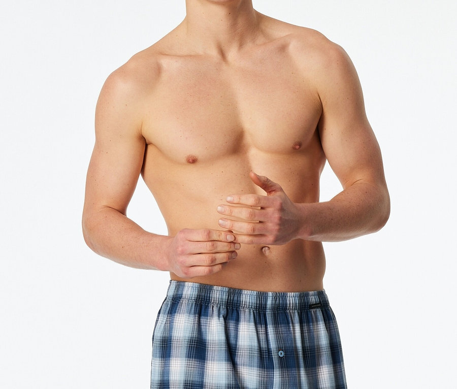 Homme torse nu portant un boxer bleu à carreaux.