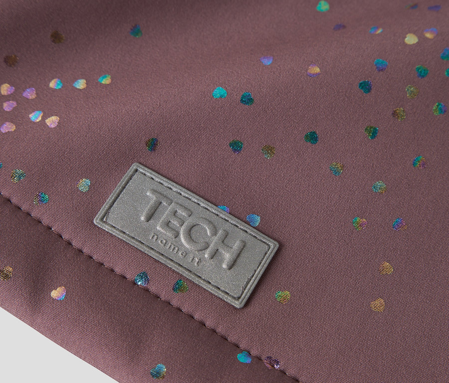 Gros plan sur un tissu marron avec des cœurs colorés et un patch gris 'TECH name it'.