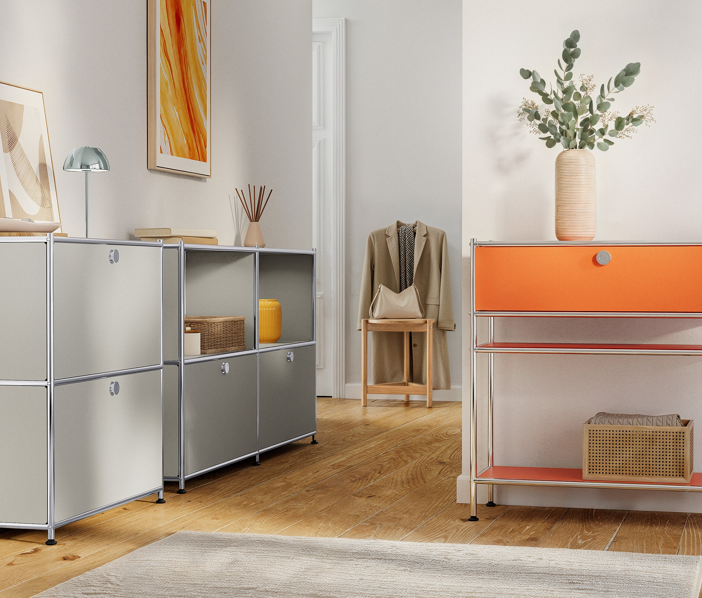 Scène d'intérieur avec des unités de rangement modulaires grises et orange, des objets décoratifs et une veste sur un tabouret.