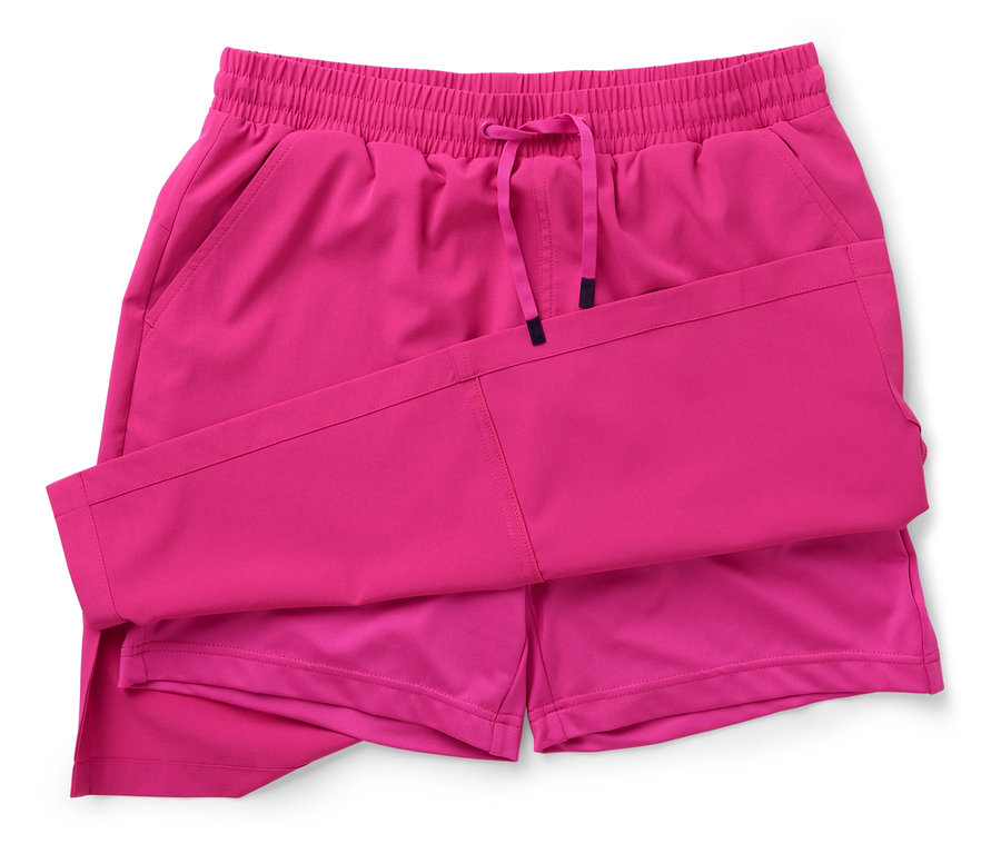 Un short rose avec cordon de serrage est plié sur un fond blanc.
