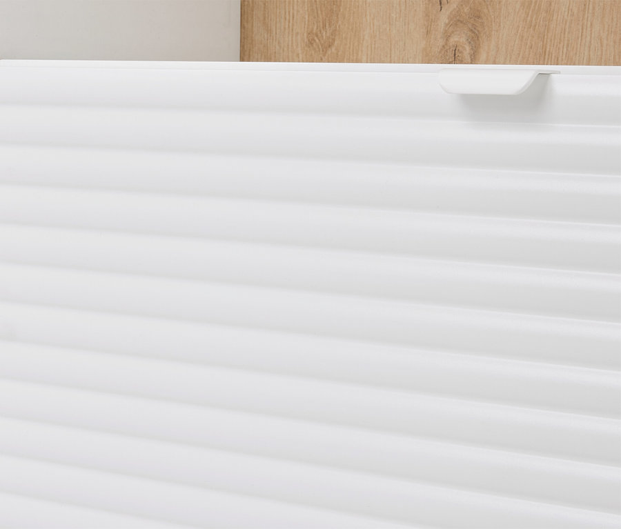 Gros plan d'une armoire blanche à rainures horizontales et d'un élément en bois marron clair en arrière-plan.