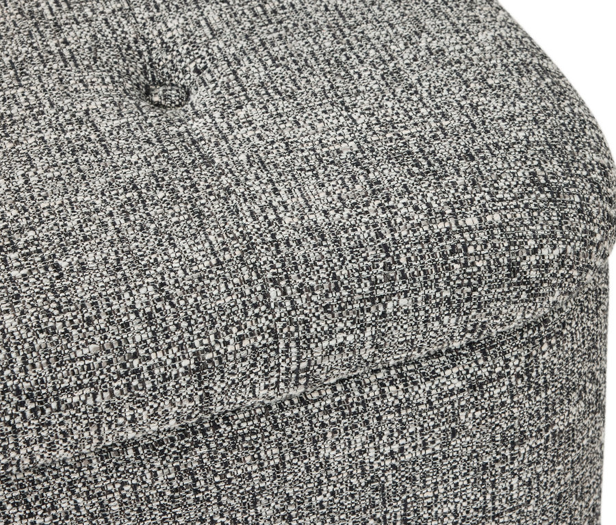 Gros plan d'un pouf gris chiné avec des boutons.