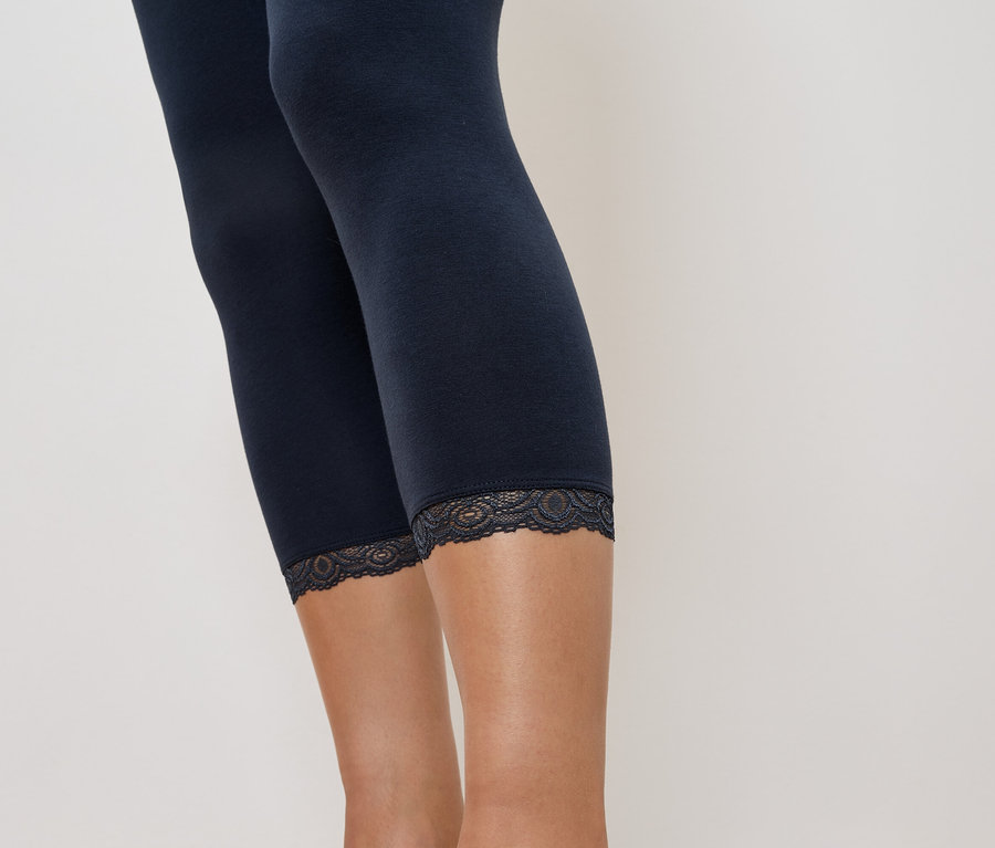 Gros plan sur un legging bleu marine avec une bordure en dentelle sur la jambe