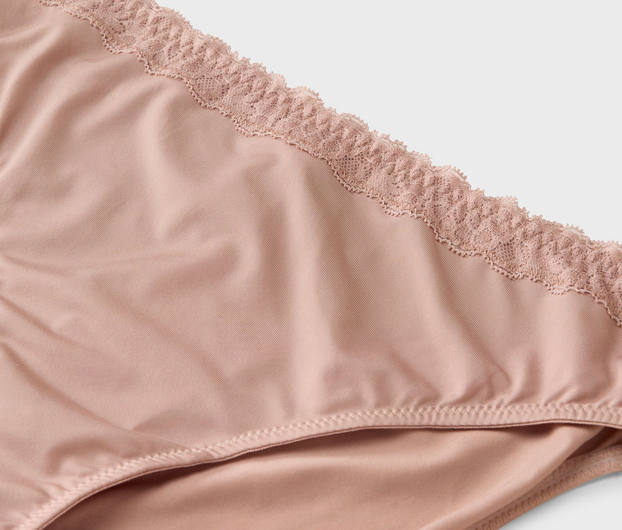 Gros plan d'une culotte rose clair avec de la dentelle à la taille.