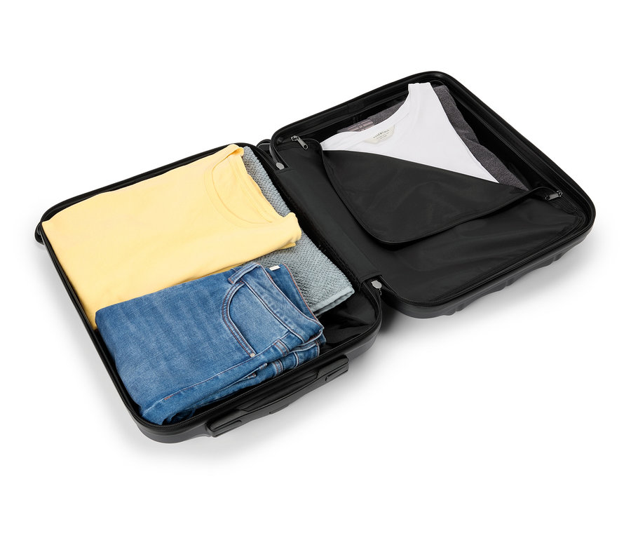 Valise noire ouverte remplie d'un t-shirt jaune, d'un pull gris et d'un jean bleu sur le côté gauche et d'un t-shirt blanc sur le côté droit.