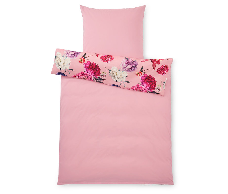 Vue de dessus d'une housse de couette rose et d'une taie d'oreiller, la taie d'oreiller et la moitié supérieure de la housse de couette présentant un motif floral.