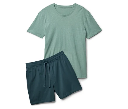 Un t-shirt vert clair est posé à côté d'un short bleu-vert foncé sur un fond blanc.