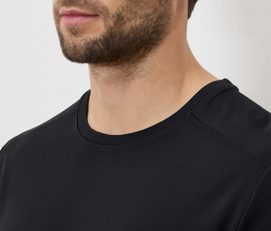 Gros plan d'un homme barbu portant un t-shirt noir.
