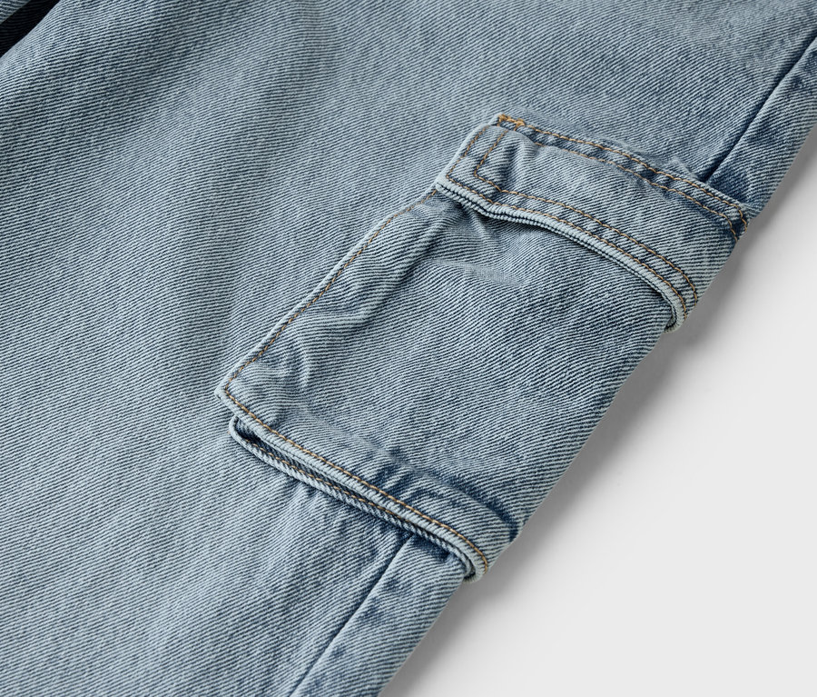 Gros plan d'un jean bleu clair avec une poche cargo.