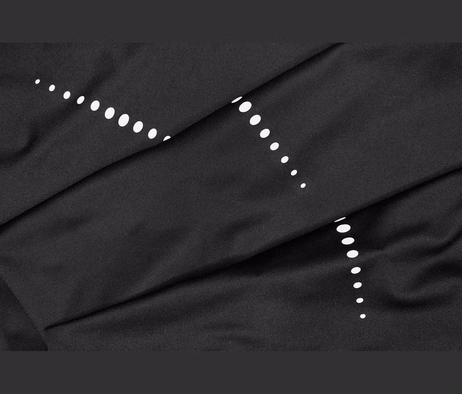 Tissu noir avec des points blancs disposés en deux lignes diagonales, présentant des plis et des froissements.