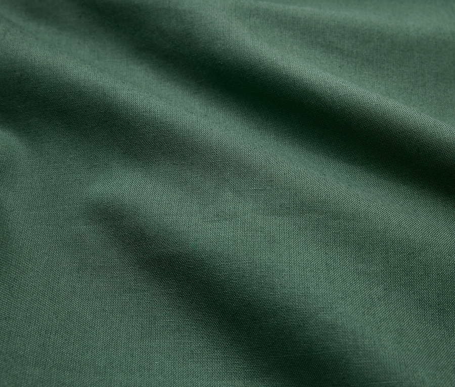 Tissu vert avec des plis et une texture légère.