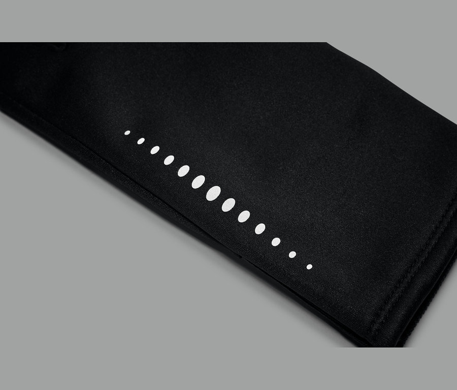 Gros plan d'un tissu noir avec une rangée de points blancs de tailles variées, allant du petit au grand et inversement.