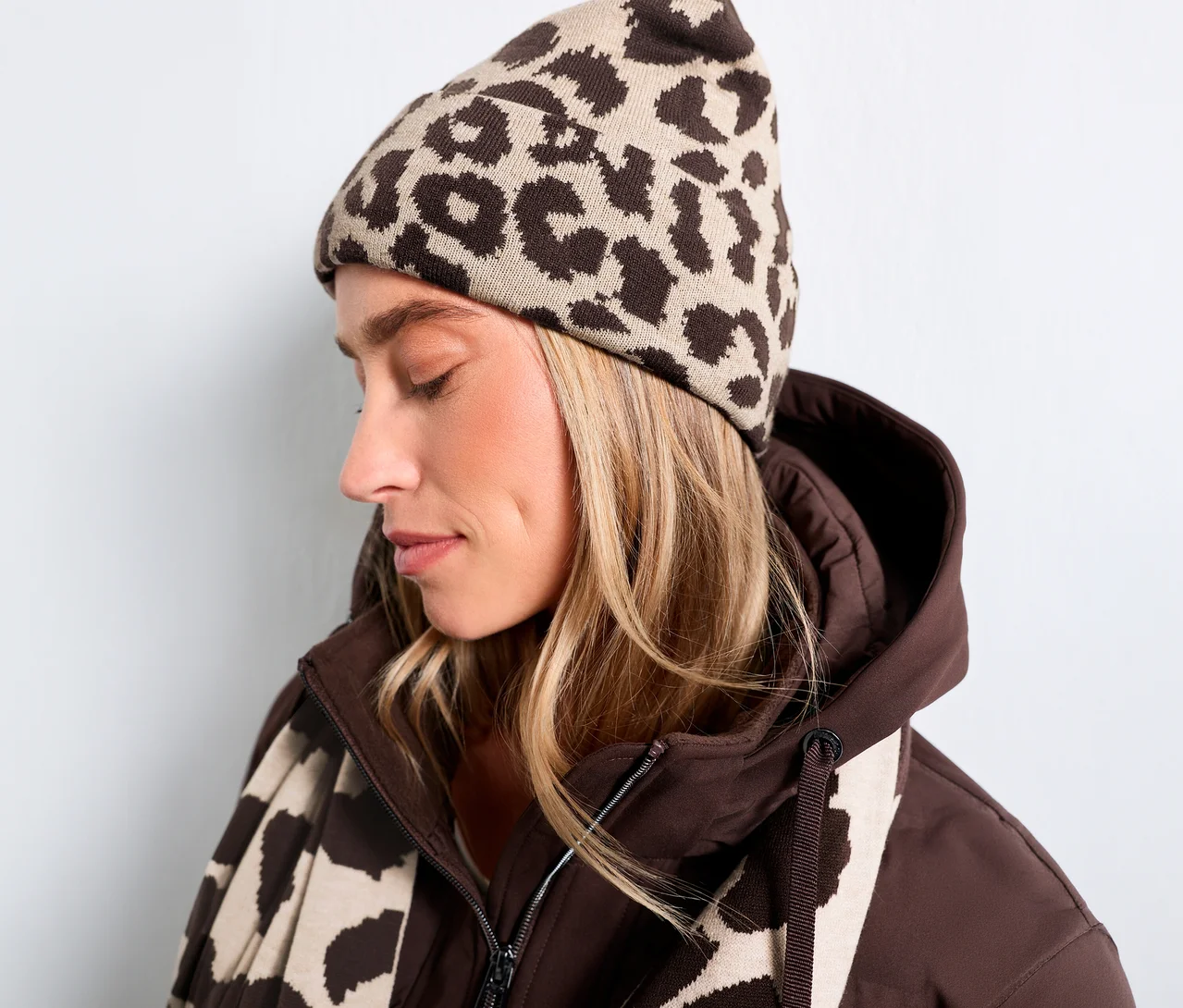 Femme portant un bonnet en tricot Street One à imprimé léopard marron, une veste marron et une écharpe assortie.