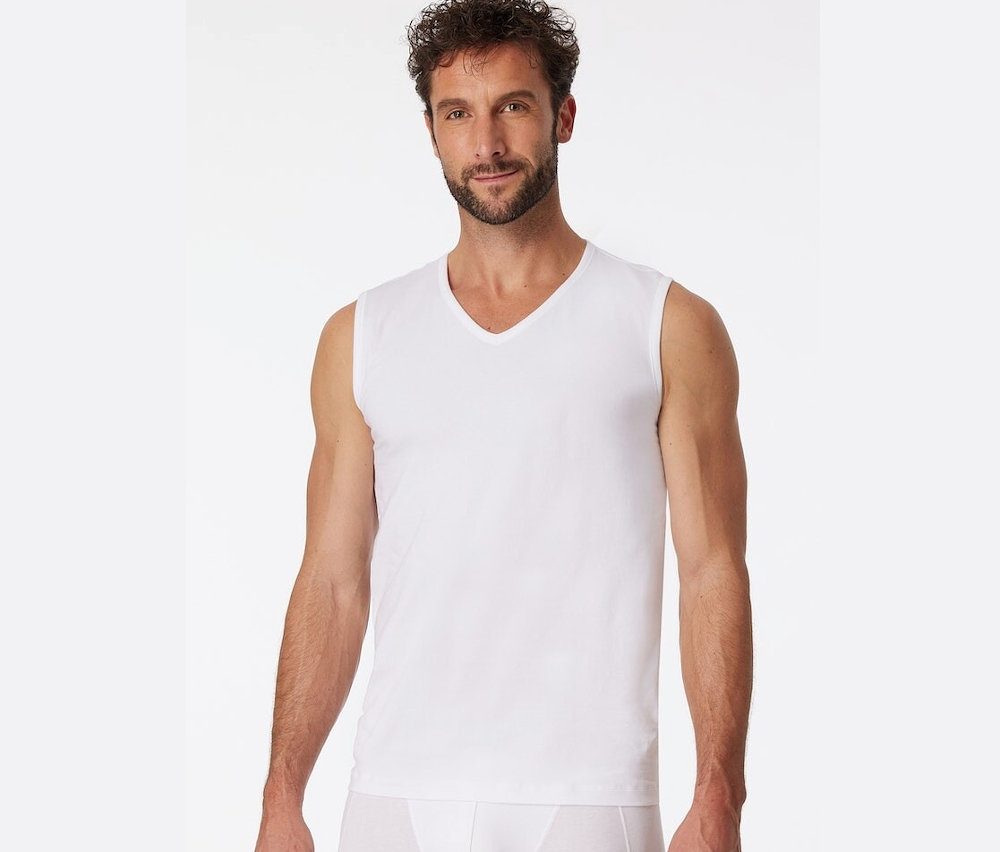 Un homme portant un des 2 débardeurs blancs SCHIESSER en coton bio.