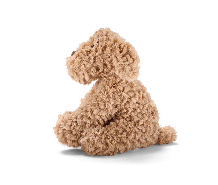 Un animal en peluche « Chien » marron est assis de côté sur un fond blanc.