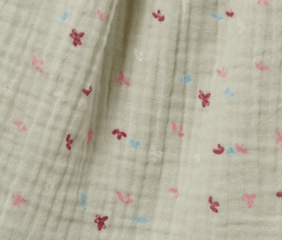 Gros plan sur une robe tissée pour bébé avec de petites fleurs.