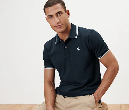 Homme assis portant un polo en piqué bleu marine.