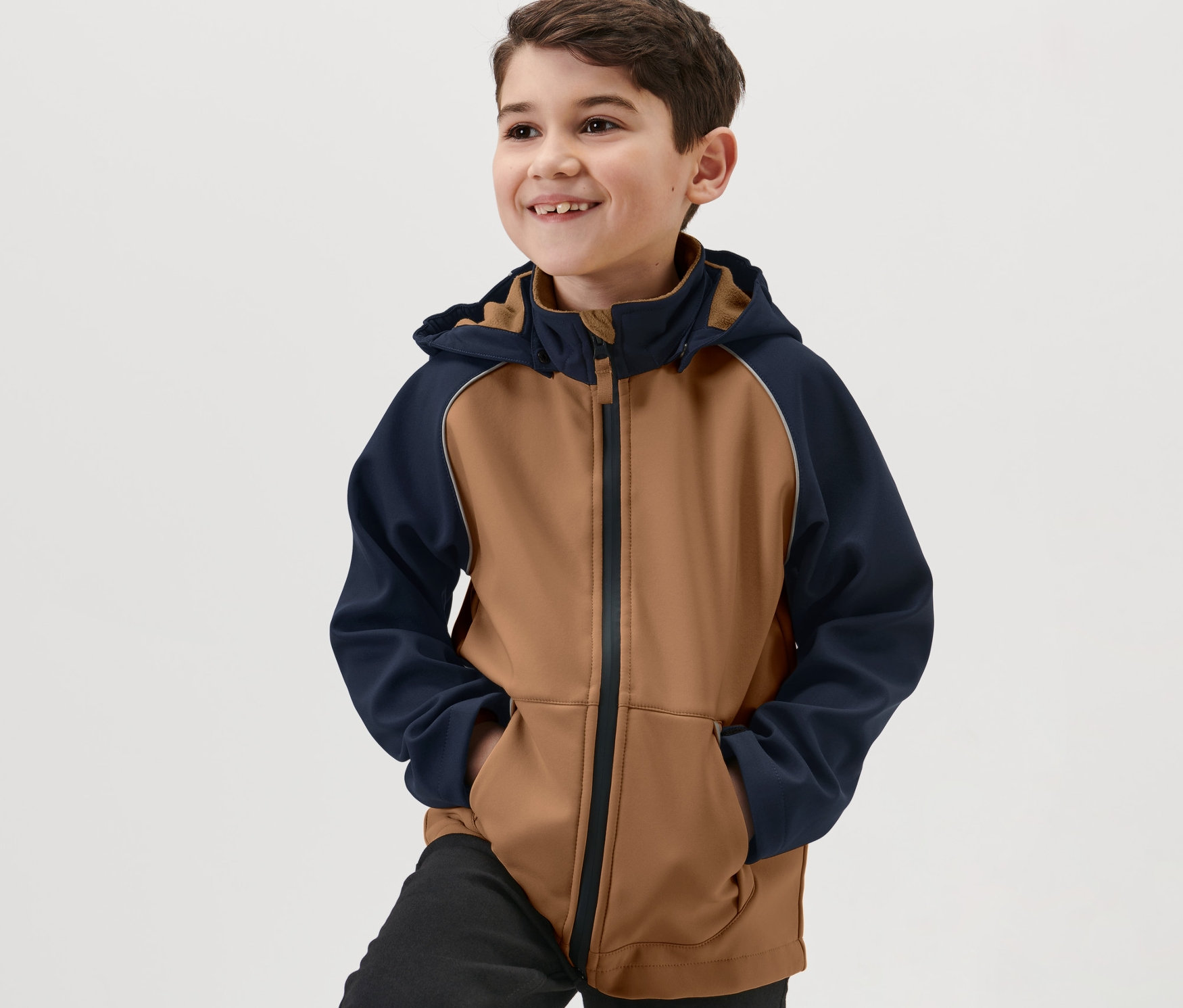 Garçon souriant portant une veste en softshell pour enfant.