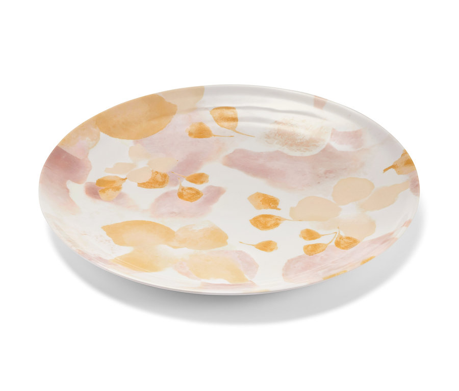 Un plat de service ovale avec un motif floral dans les tons pêche et rose.