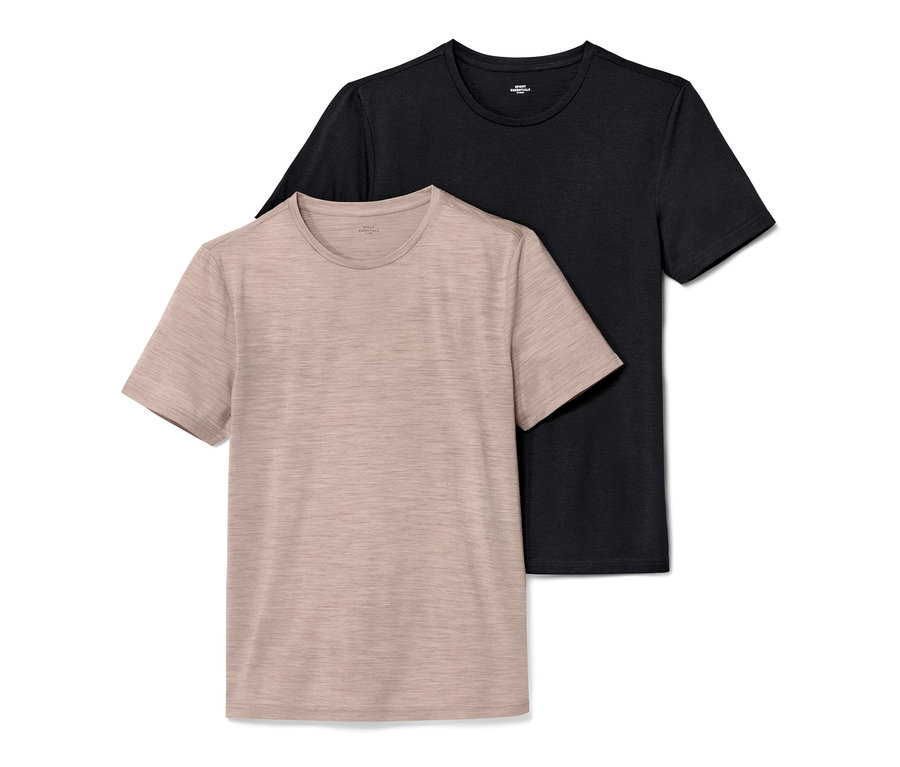 Deux t-shirts à manches courtes : un t-shirt beige en laine mérinos au premier plan et un t-shirt noir à l’arrière-plan.