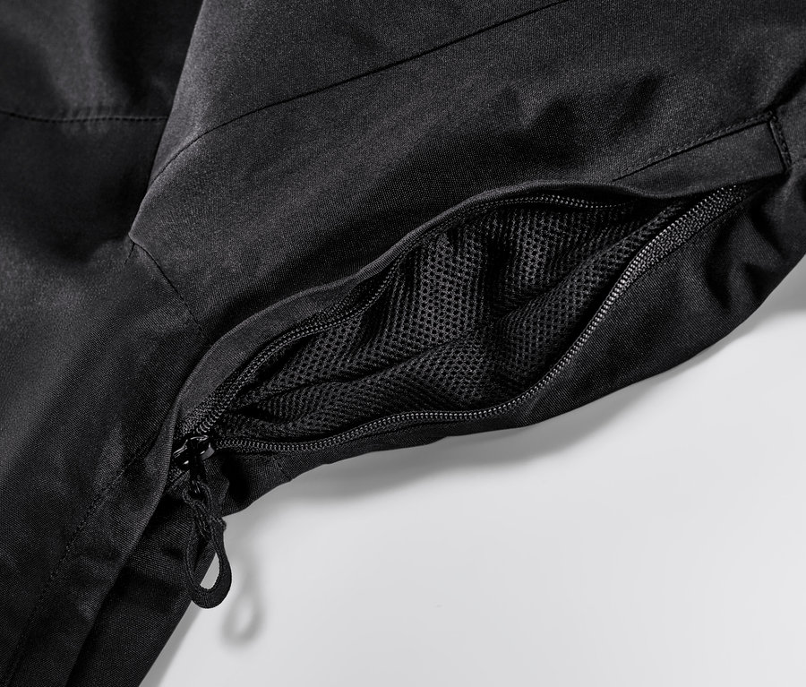 Détail d'une veste de ski noire avec fermeture éclair et poche en filet.
