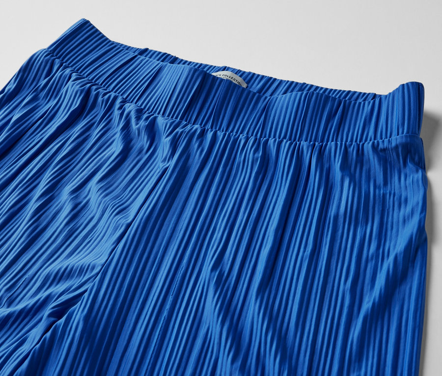 Gros plan sur un pantalon plissé bleu cobalt.
