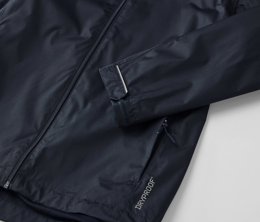 Gros plan sur une veste de pluie unisexe foncée avec une bande réfléchissante sur la manche.