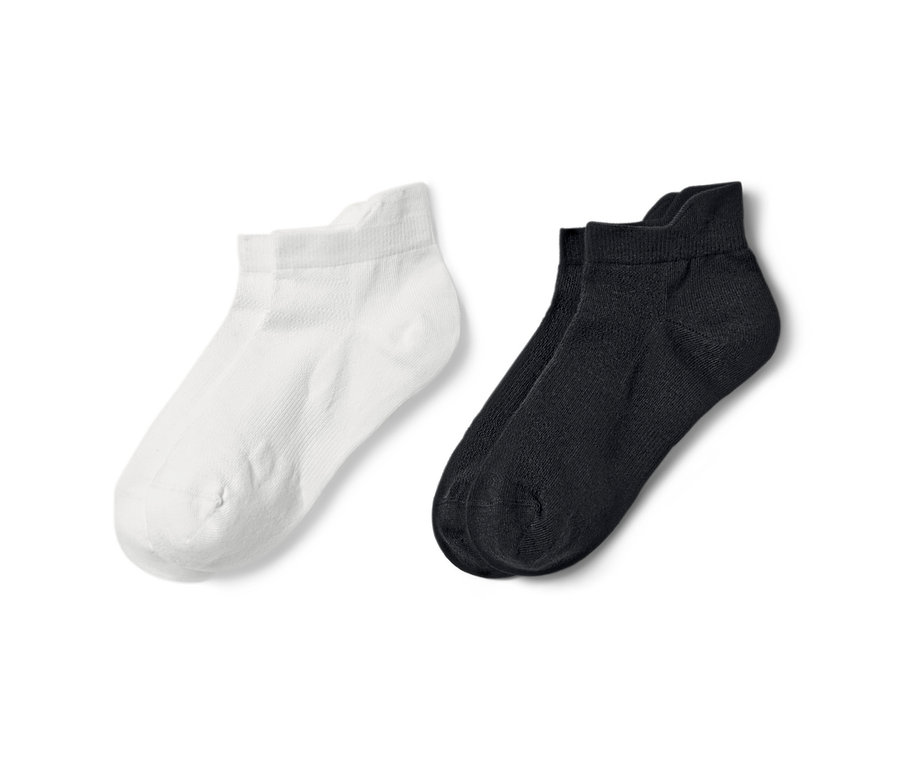 Deux paires de socquettes de sport, une paire blanche, une paire noire.