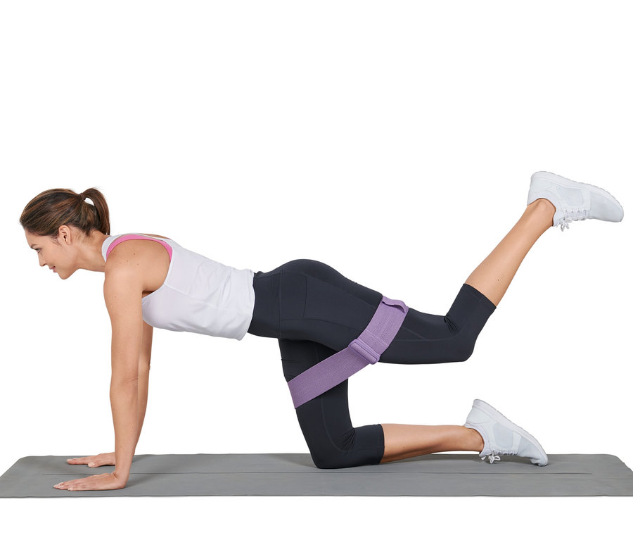 Femme faisant des exercices sur un tapis avec une bande de fitness ajustable.