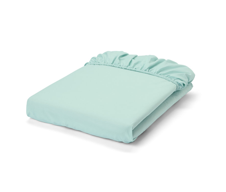 Un drap-housse en percale bleu clair plié.