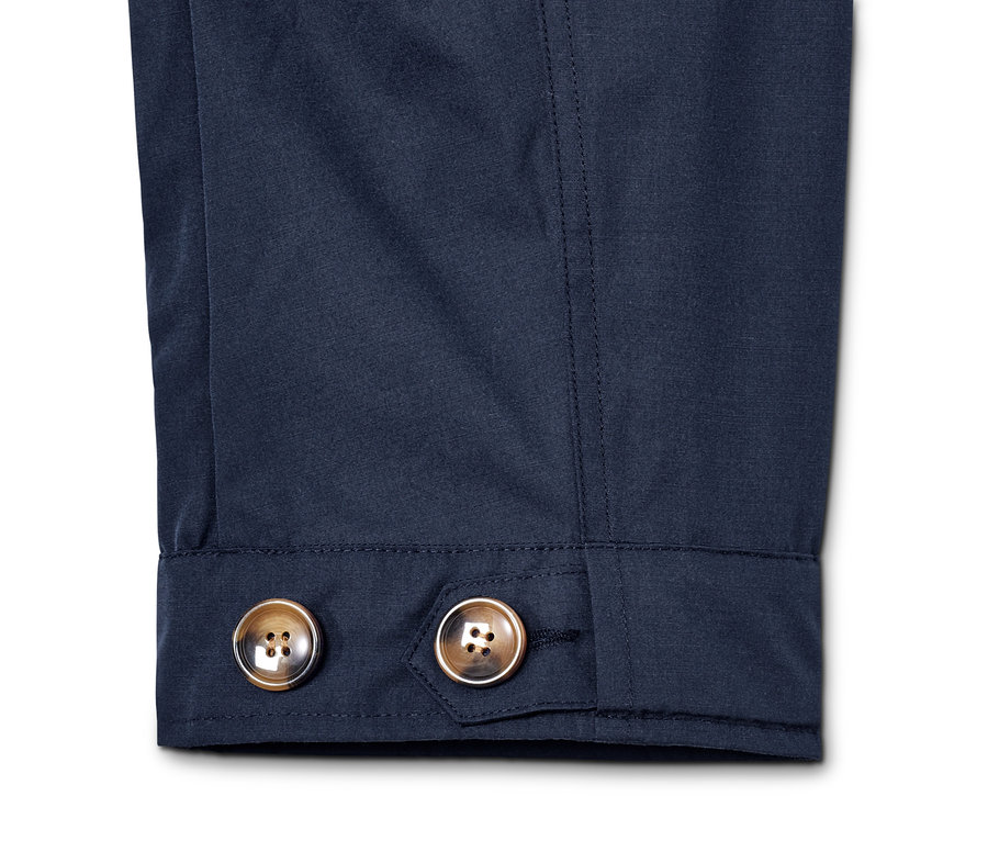 Gros plan sur la manche d'une parka à capuche avec deux boutons.