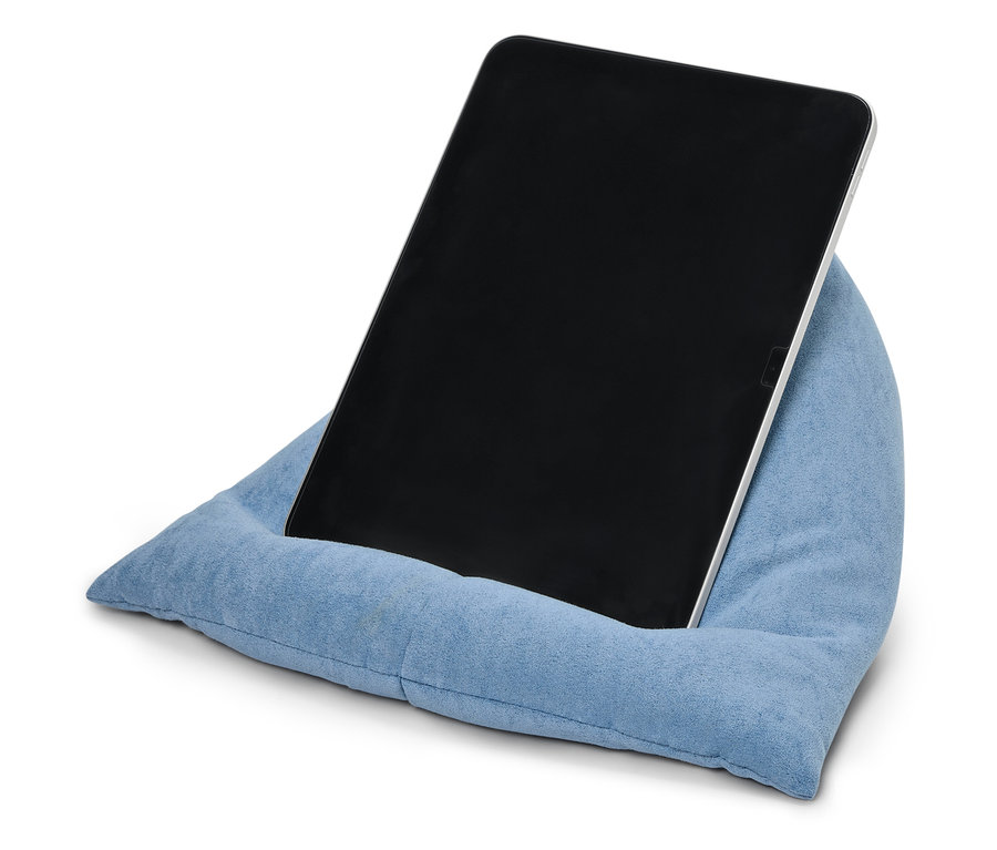 Une tablette appuyée contre un coussin bleu.