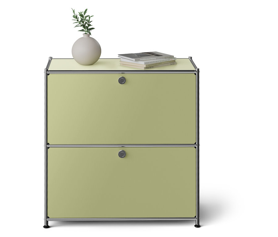 Armoire verte avec deux tiroirs. Vase et livre sur le dessus.