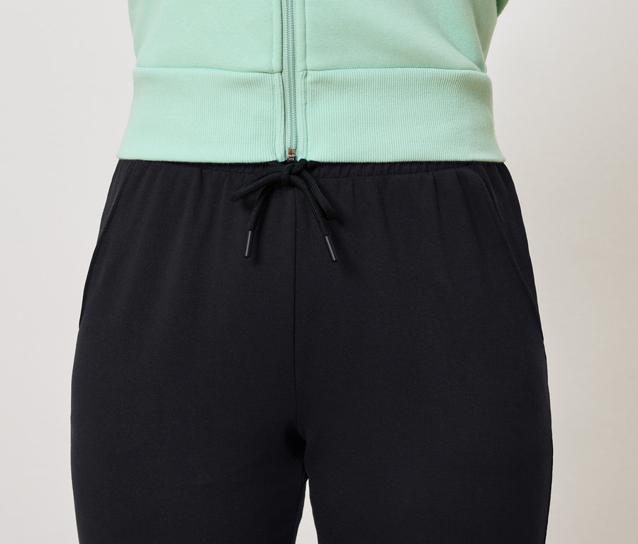 Pantalon de survêtement noir avec cordon de serrage et veste vert clair.