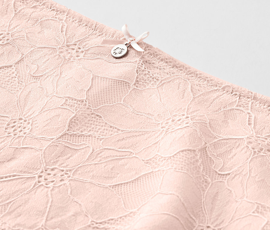 Détail d'un panty taille haute « sculptant légèrement la silhouette », rose.