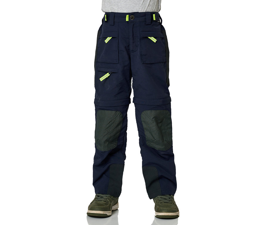 Pantalon zip-off JAKO-O marine avec des accents jaune fluo et des renforts aux genoux, porté avec des baskets vertes.